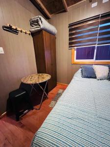 a bedroom with a bed and a table in it at Casa alojamiento Peumallen in Puerto Varas