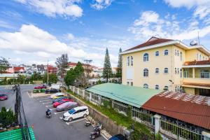 a parking lot with cars parked in front of a building at Gia Khanh Hotel in Da Lat