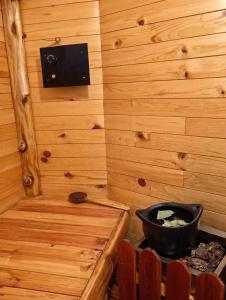 a room with a stove in a wooden room at Cabaña en la Calera el Pinar in La Calera