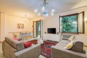 a living room with two couches and a television at Villa Alberti 900m from Garda lake with Garden in Salò