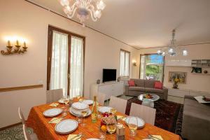 a dining room with a table and a living room at Villa Alberti 900m from Garda lake with Garden in Salò