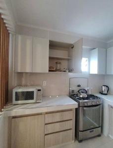 a kitchen with a microwave and a stove at La posada apartment in Cusco