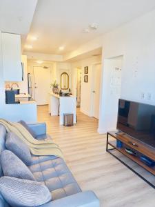 a living room with a couch and a tv at Downtown Condo, Stylish Comfy in Calgary