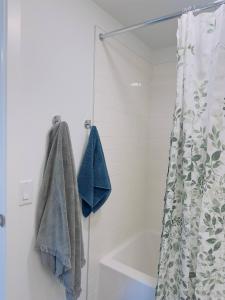 a bathroom with a shower curtain and a bath tub at Downtown Condo, Stylish Comfy in Calgary +5 photos