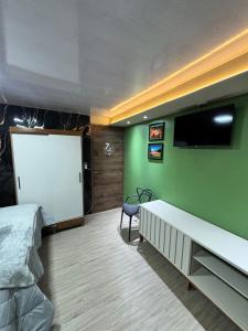 a bedroom with a bed and a flat screen tv at Casa Bri in Antiguo Cuscatlán