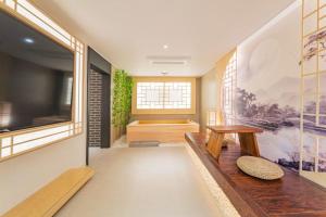 a living room with a bench and a television at Yeonhwamoon Hotel Yangyang in Yangyang