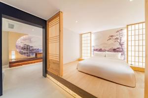 a bedroom with a bed and a painting on the wall at Yeonhwamoon Hotel Yangyang in Yangyang