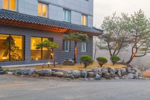 a building with a landscaping in front of a house at Yeonhwamoon Hotel Yangyang in Yangyang