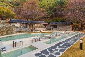 an outdoor swimming pool with tables and benches at Yeonhwamoon Hotel Yangyang in Yangyang