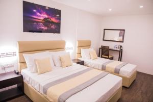 um quarto de hotel com duas camas e uma secretária em Venue Colombo em Colombo