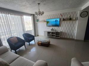 a living room with a couch and a tv at Apart colección cusco in Cusco
