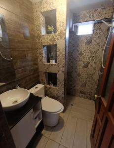 a bathroom with a toilet and a sink at Apart colección cusco in Cusco