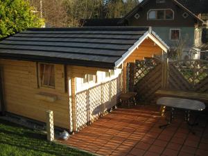 eine Holzterrasse mit Dachschräge auf einem Haus in der Unterkunft Ferienwohnung Huber in Opfenbach