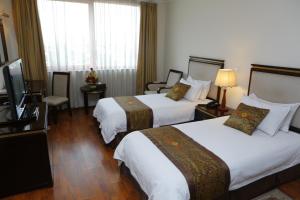 a hotel room with two beds and a flat screen tv at Wassamar Hotel in Addis Ababa
