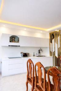 a kitchen with a table and two wooden chairs at Sunhouse Villa Huế in Hue