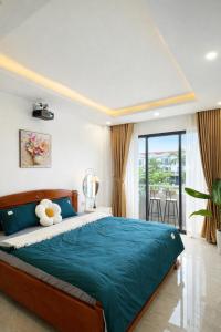 a bedroom with a large bed and a balcony at Sunhouse Villa Huế in Hue