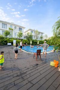 a group of people standing around a swimming pool at Sunhouse Villa Huế in Hue