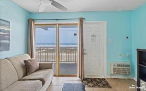 a living room with a couch and a sliding glass door at 1 Bedroom Beach Condo with a Pool & Balcony in Wildwood Crest