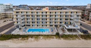 a large building with a swimming pool in front of it at 1 Bedroom Beach Condo with a Pool & Balcony in Wildwood Crest