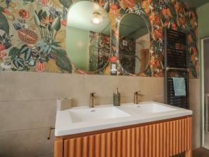 a bathroom with a sink and two mirrors at Canalside Cottage in Kildwick +37 photos