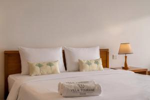 a white bed with two towels on top of it at The Bada studio apartment - ocean view in Danang +8 photos