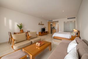 a living room with a couch and a bed at The Bada studio apartment - ocean view in Danang