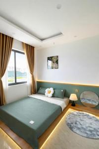 a bedroom with a large green bed with a window at Sunhouse Villa Huế in Hue +55 photos