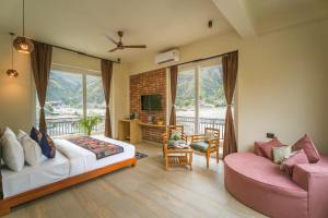 a living room with a bed and a couch at Tripli Hotels Sukritham in Narendranagar