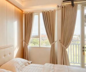 a bedroom with a bed and a large window at M Apartement in Seturan