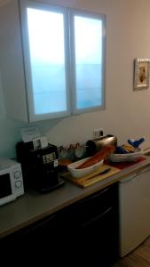 a kitchen counter with two windows and a microwave at Alojamiento EntreHoces in Cuenca +11 photos