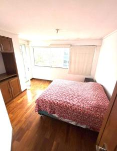 a bedroom with a bed and a window in it at El departamento de manolo in Cusco