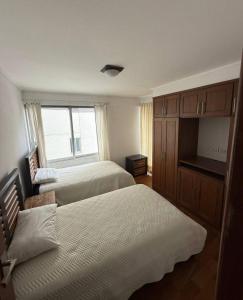 a hotel room with two beds and a television at El departamento de manolo in Cusco