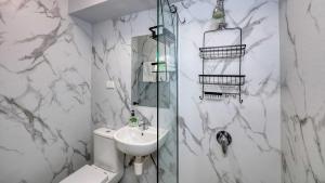 a bathroom with a toilet and a sink and a shower at AZA Motel in Lismore +25 photos