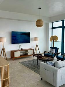 a living room with a couch and a tv at JUAN DOLIO 2BR Beach front SALITRE across Club Hemingway in Juan Dolio