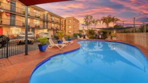 a large blue swimming pool in a hotel courtyard at AZA Motel in Lismore