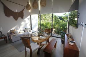 a living room with a table and a couch at Luxury Jungle Loft, 7 Pools, Rooftop Panoramic View, Beach Shuttle, Fast WiFi in Tulum
