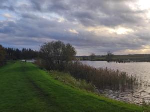 a path next to a river with a cloudy sky at Huis-Meerwijck in Kropswolde