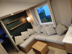 a small living room with a couch and a window at Huis-Meerwijck in Kropswolde