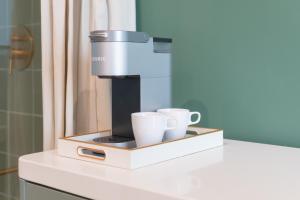 a coffee machine sitting on a counter with two cups at Hotel Beebop in Toronto