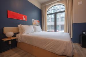 a bedroom with a large bed with a window at Hotel Beebop in Toronto
