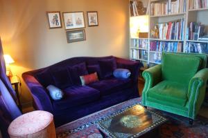 ポールバイユにあるLa Maison roseのリビングルーム(紫色のソファ、緑色の椅子2脚付)
