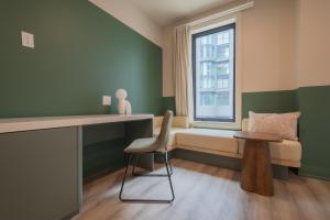 a room with a desk and a chair and a window at Hotel Beebop in Toronto