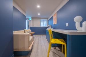 a blue room with a desk and a yellow chair at Hotel Beebop in Toronto +28 photos