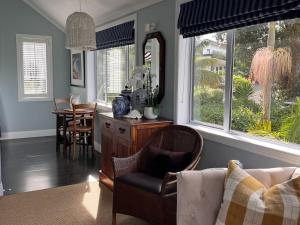 a living room with a chair and a mirror and a table at The Boat House Studio in Tairua