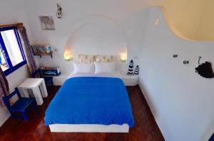una camera da letto con un letto blu in una stanza bianca di Little Path Kenting a Eluan