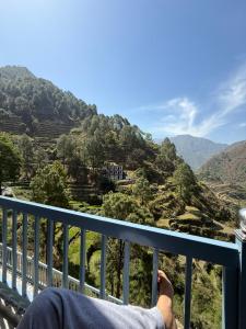 a person sitting on a balcony looking at the mountains at Panwar home stay in Partābnagar