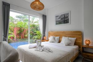 a bedroom with a bed and a large window at Polly Canggu 1BR Private Pool Villa By Bali Bliss Properties in Buduk +13 photos