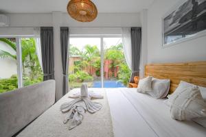 a bedroom with a white bed with towels on it at Polly Canggu 1BR Private Pool Villa By Bali Bliss Properties in Buduk