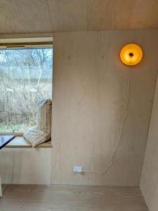 a room with a window and a light on the wall at Architectural Tiny House With Sauna Near Beach in Asnæs