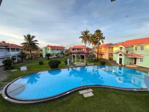 an overhead view of a large swimming pool in front of houses at Pool View Villa & Apartment By The Beach Goa in Benaulim